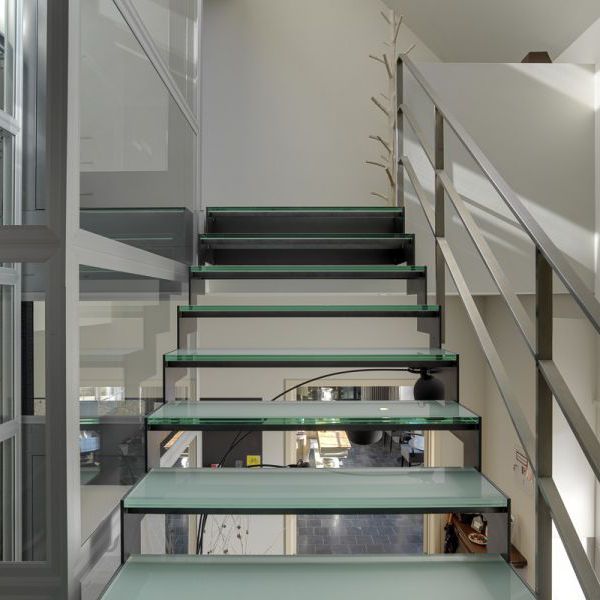 Moderne trappen met treden en trapleuning in staal, inox en glas. 